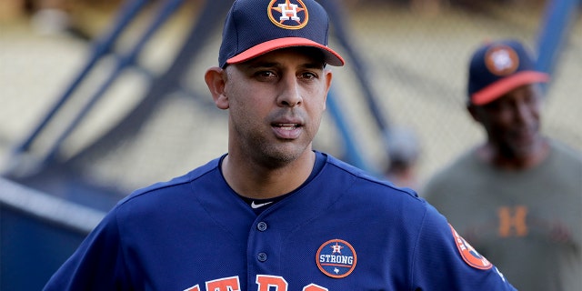 In this Oct. 23, 2017, file photo, Houston Astros bench coach Alex Cora watches batting practice during media day for baseball's World Series against the Los Angeles Dodgers, in Los Angeles. Houston manager AJ Hinch and general manager Jeff Luhnow were suspended for the entire season Monday, Jan. 13, 2020, and the team was fined $5 million for sign-stealing by the team in 2017 and 2018 season. (AP Photo/David J. Phillip, File)