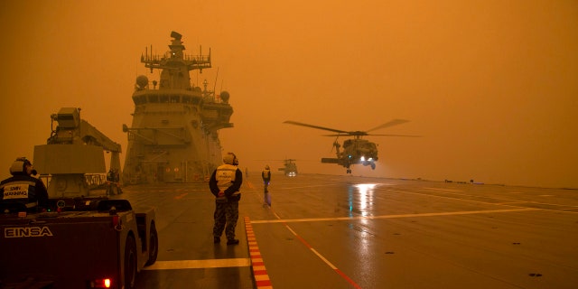 In this photo provided by the Australian Department of Defense, a Royal Australian Navy Seahawk Helicopter departs from HMAS Adelaide while at sea off Australia's east coast, Sunday, Jan. 5, 2020, during operations to assist in battling wildfires.