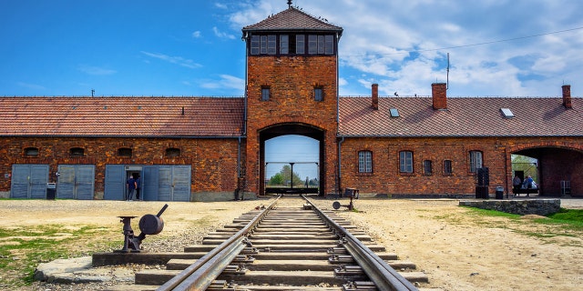 The main gate to the nazi concentration camp of Auschwitz Birkenau with train rail, Poland.