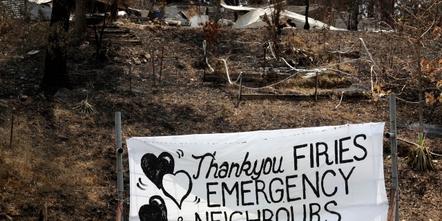 A sign is displayed beside a burned-out house near Mogo, Australia, Thursday, Jan. 9, 2020, thanking "firies" a colloquial term for firefighters.