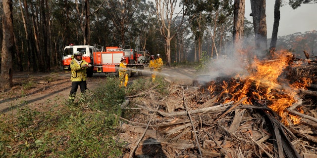 Firefighters battle a fire near Bendalong, Australia, Friday, Jan. 3, 2020.