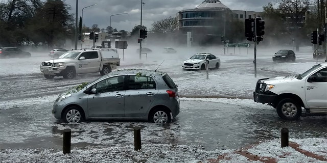 Hail covers vehicles in an intersection Monday, Jan. 20, 2020, in Canberra, Australia.