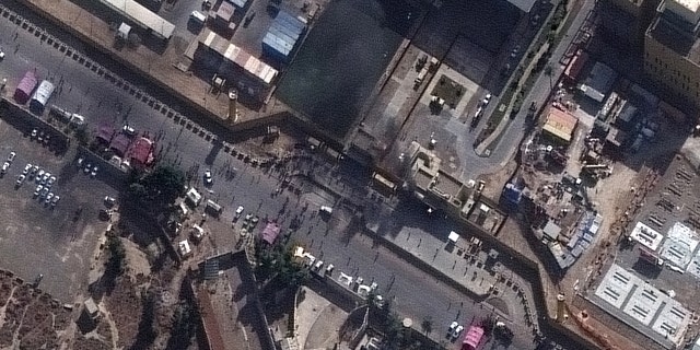 Satellite image of crowds and a small fire at the western entrance to the U.S. Embassy compound in Baghdad on Jan. 1, 2020. (Satellite image ©2020 Maxar Technologies)