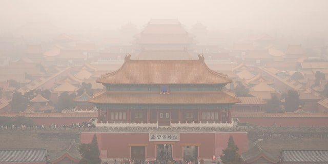Tourists exit the Forbidden City in Beijing, Saturday, Jan. 18, 2020. A Chinese woman sparked social media outrage in her country by posting photos of herself and a friend with a Mercedes-Benz SUV on the grounds of Beijing's landmark Forbidden City, prompting an apology from the management of China's former imperial palace. (AP Photo/Mark Schiefelbein)