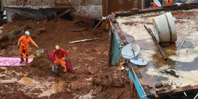 Firefighters search for victims near houses destroyed by a landslide after heavy rains in Barreiro, Minas Gerias state, Brazil, Saturday, Jan.25, 2020.