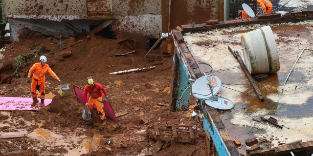 Firefighters search for victims near houses destroyed by a landslide after heavy rains in Barreiro, Minas Gerias state, Brazil, Saturday, Jan.25, 2020.