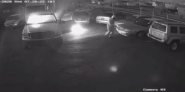 A man can be seen setting vehicles on fire in the parking lot of a business earlier this month in Phoenix.