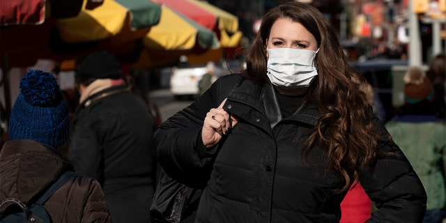 A woman, who declined to give her name, wears a mask, Thursday, Jan. 30, 2020 in New York City. She works for a pharmaceutical company and said she wears the mask out of concern for the coronavirus. (Associated Press)