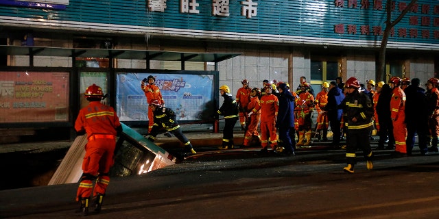 Firefighters descended into the chasm that opened up and swallowed the bus to rescue the victims. (Ma Minyan/cnsphoto via AP)