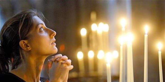 Une femme en prière dans une église