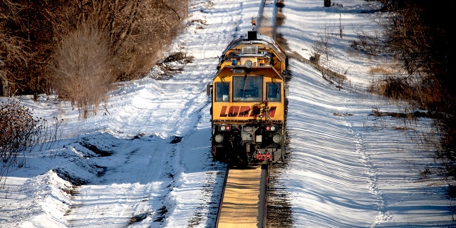 A train makes its way along a path where corn spilled from a train on a Canadian Pacific line in Crystal, Minn.