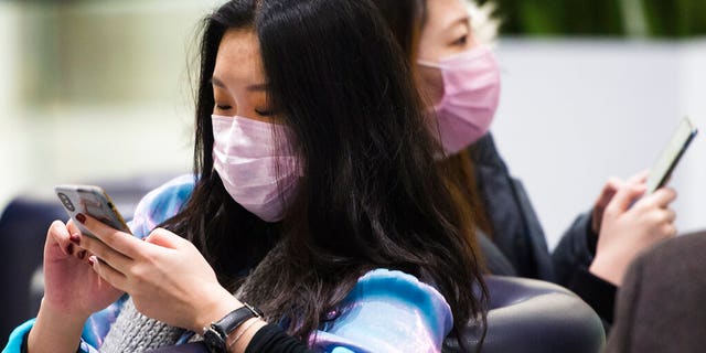 People wear masks following the outbreak of a new virus as people arrive from the International terminal at Toronto Pearson International Airport in Toronto on Saturday, Jan. 25, 2020. A Toronto hospital said Saturday it has a confirmed case of the deadly virus from China, Canada's first. Sunnybrook Health Sciences Centre said it is "caring for a patient who has a confirmed case of the novel coronavirus that originated in Wuhan, China." (Nathan Denette/The Canadian Press via AP)
