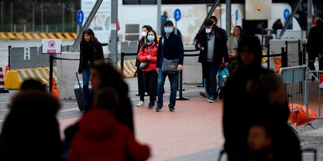 Passengers are seen exiting the port it Civitavecchia early on Jan. 31 after Italy's Ministry of Health confirmed the sick passenger tested negative for the coronavirus.