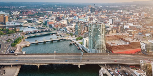 Aerial view over the City of Belfast along the River Lagan with Lagan Bridge in the foreground, ICC Belfast, Lagan Boat and Victoria Square Dome. Belfast, North Ireland, UK