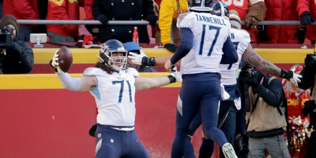 Tennessee Titans' Dennis Kelly (71) celebrating his touchdown catch with quarterback Ryan Tannehill (17) during the first half of the NFL AFC Championship game against the Kansas City Chiefs on Sunday. (AP Photo/Charlie Riedel)