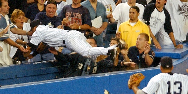 FILE - In this July 1, 2004, file photo, New York Yankees Derek Jeter dives to catch a fly foul ball in the 12th inning during a baseball against the Boston Red Sox at New York's Yankee Stadium.