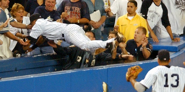 File-In this July 1, 2004 file photo, the New York Yankees Derek Jeter jumps in to catch a fly foul ball in the 12th inning during a baseball game against the Boston Red Sox at the Yankee Stadium in New York. I did.