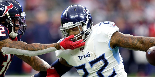 Houston Texans cornerback Lonnie Johnson (32) reaches to tackle Tennessee Titans running back Derrick Henry (22) during the first half of an NFL football game Sunday, Dec. 29, 2019, in Houston. (AP Photo/Michael Wyke)