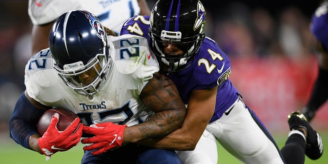 Baltimore Ravens cornerback Marcus Peters (24) hits Tennessee Titans running back Derrick Henry (22) during an NFL divisional playoff football game, Saturday, Jan. 11, 2020, in Baltimore. (AP Photo/Nick Wass)