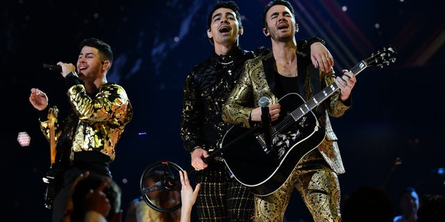 Nick Jonas, Joe Jonas, and Kevin Jonas of music group Jonas Brothers perform onstage during the Grammys.