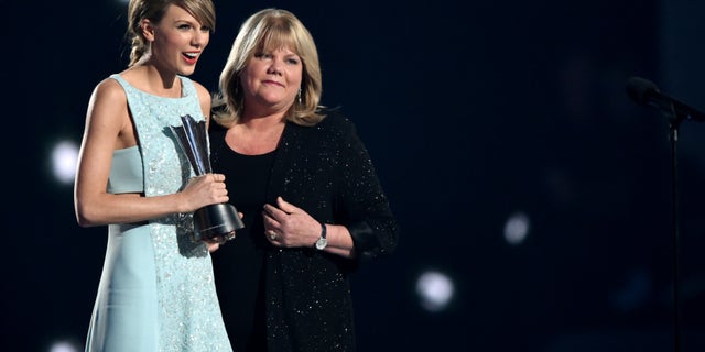 Honoree Taylor Swift, left, accepts the Milestone Award from Andrea Swift onstage during the 50th Academy Of Country Music Awards at AT&T Stadium on April 19, 2015.