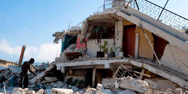 A man searching through the rubble of buildings in the wake of the Jan. 12, 2010 earthquake that devastated Haiti.