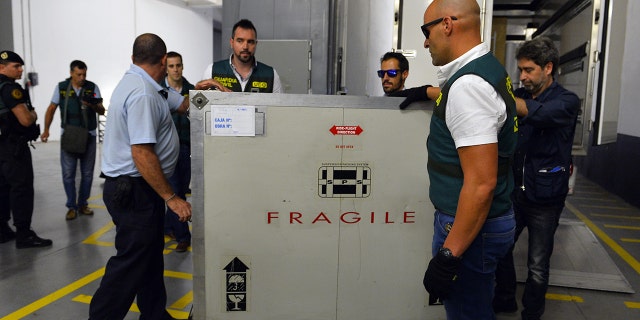 Spanish Civil Guards and museum employees push a box containing Picasso's painting "Head of a Young Woman" at the Reina Sofia museum in Madrid after being transferred from the French island of Corsica, on August 11, 2015. (GERARD JULIEN/AFP via Getty Images)