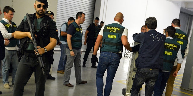 Spanish Civil Guards push a box containing Picasso's painting "Head of a Young Woman" at the Reina Sofia museum in Madrid after being transferred from the French island of Corsica, on August 11, 2015. (GERARD JULIEN/AFP via Getty Images)