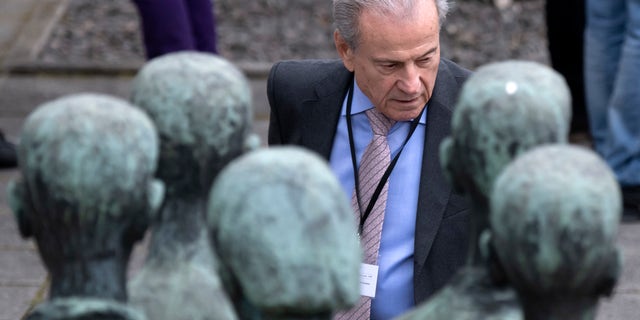 Former Nazi concentration camp survivor Jerry Wartski from the USA stands behind the memorial during the commemoration ceremonies for the 73th anniversary of the liberation of former Nazi concentration camp Mittelbau-Dora near Nordhausen, Germany, Wednesday, April 11, 2018. (AP Photo/Jens Meyer)