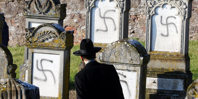 Chief Rabbi Harold Abraham Weill looks at graves desecrated with swastikas at the Jewish cemetery in Westhoffen, near Strasbourg, France, December 4, 2019. (REUTERS/Arnd Wiegmann)