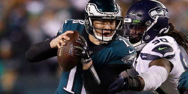 Philadelphia Eagles' Josh McCown (18) tries to get past Seattle Seahawks' Jadeveon Clowney (90) as Miles Sanders (26) tries to defend during the first half of an NFL wild-card playoff football game, Domenica, Jan. 5, 2020, a Philadelphia.