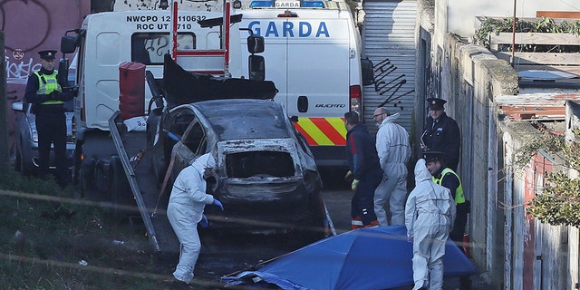 A burnt out car which contained human remains, believed to be linked to the disappearance of a 17-year-old boy from Co Louth, is removed from the scene on Trinity Terrace in the Drumcondra area of Dublin. (Press Association via AP Images)