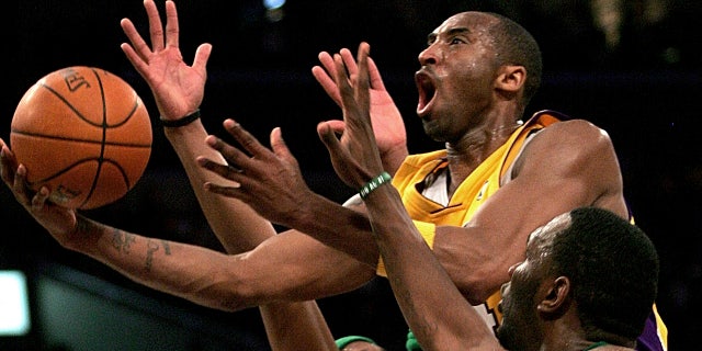 Los Angeles Lakers' Kobe Bryant goes up for a shot between the Boston Celtics' Paul Pierce, left, and Al Jefferson during the first half of an NBA basketball game in Los Angeles. (AP Photo/Branimir Kvartuc, File)