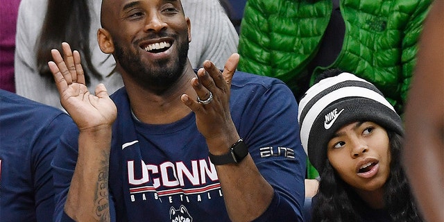 In this March 2, 2019 photo, Kobe Bryant and his daughter Gianna watch the first half of an NCAA college basketball game between Connecticut and Houston in Storrs, Conn. Bryant, the 18-time NBA All-Star who won five championships and became one of the greatest basketball players of his generation during a 20-year career with the Los Angeles Lakers, died in a helicopter crash Sunday, Jan. 26, 2020. Gianna also died in the crash. (AP Photo/Jessica Hill)
