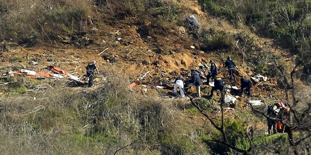 Investigators work the scene of a helicopter crash that killed former NBA basketball player Kobe Bryant, his 13-year-old daughter, Gianna, and several others Monday, Jan. 27, 2020, in Calabasas, Calif. (AP Photo/Mark J. Terrill)