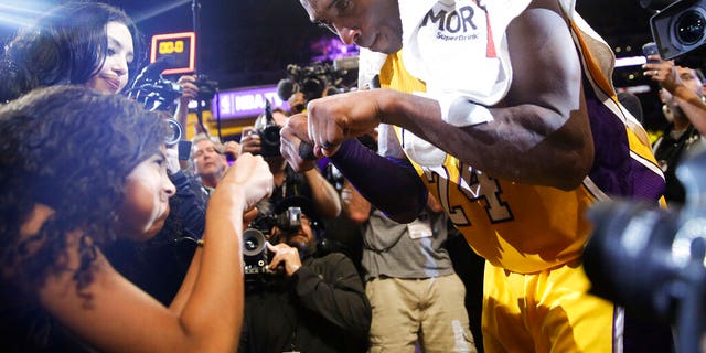 FILE - In this April 13, 2016 file photo Los Angeles Lakers' Kobe Bryant, right, fist-bumps his daughter Gianna after the last NBA basketball game of his career. (AP Photo/Jae C. Hong, file)