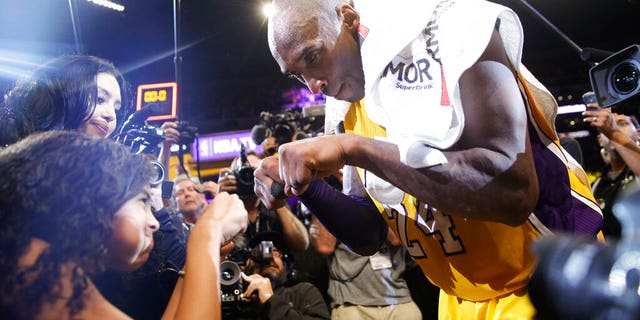 FILE - In this April 13, 2016 file photo Los Angeles Lakers' Kobe Bryant, right, fist-bumps his daughter Gianna after the last NBA basketball game of his career. (AP Photo/Jae C. Hong, file)