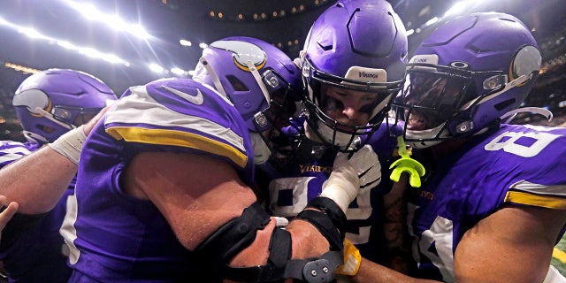 Minnesota Vikings tight end Kyle Rudolph, center, congratulated by teammates after catching the game-winning touchdown pass during overtime of their game against the Minnesota Vikings on Sunday. (AP Photo/Brett Duke)