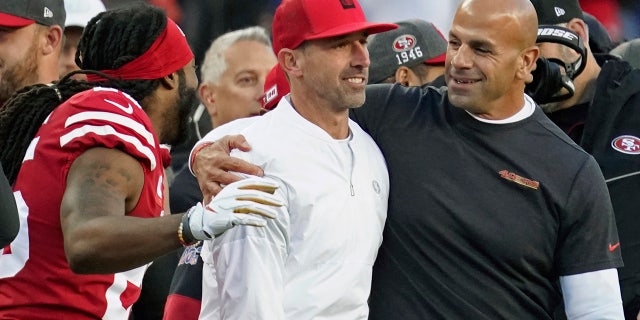 San Francisco 49ers head coach Kyle Shanahan, center, is greeted by with cornerback Richard Sherman, left, and defensive coordinator Robert Saleh, right, in the final minutes of the second half of an NFL divisional playoff football game against the Minnesota Vikings, Saturday, Jan. 11, 2020, in Santa Clara, Calif. The 49ers won 27-10. (AP Photo/Tony Avelar)