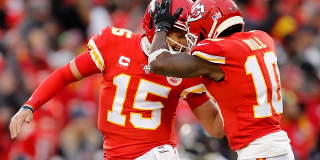 堪萨斯城酋长队四分卫Patrick Mahomes(15)在季后赛上半场对阵休斯敦德州人的比赛中,与广泛的接球手Tyreek Hill进行了庆祝。 (美联社照片/杰夫罗伯森)