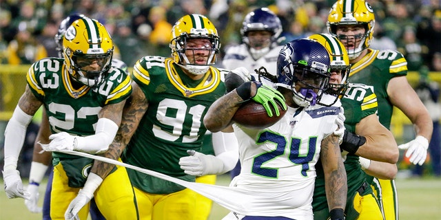 Green Bay Packers' Jaire Alexander (23) and others try to stop Seattle Seahawks' Marshawn Lynch (24) during the first half of an NFL divisional playoff football game Sunday. (AP Photo/Mike Roemer)