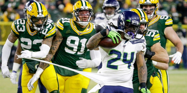 Green Bay Packers' Jaire Alexander (23) and others try to stop Seattle Seahawks' Marshawn Lynch (24) during the first half of an NFL divisional playoff football game Sunday. (AP Photo/Mike Roemer)