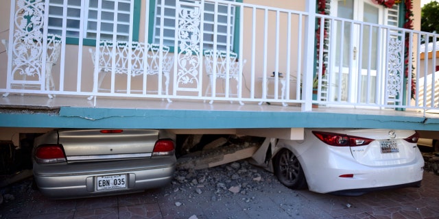 Cars are crushed under a home that collapsed after an earthquake hit Guanica, Puerto Rico, Monday, Jan. 6, 2020.