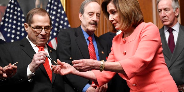 House Speaker Nancy Pelosi of Calif., second from right, gives pens to fellow Democrats after she signed the resolution to transmit the two articles of impeachment against President Donald Trump to the Senate for trial on Capitol Hill in Washington, Wednesday, Jan. 15, 2020. (Associated Press)