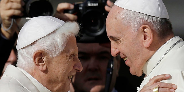 Pope Francis, right, hugging Pope Benedict XVI prior to the start of a meeting with elderly faithful in St. Peter's Square at the Vatican in 2014. (AP Photo/Gregorio Borgia, File)