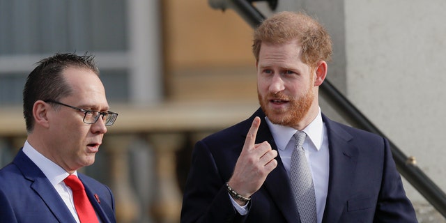 Prince Harry gestures in the gardens at Buckingham Palace in London, Thursday, Jan. 16 ahead of hosting the Rugby League World Cup 2021 draw.