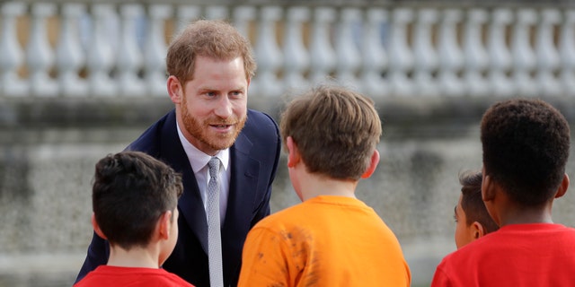 Britain's Prince Harry greets schoolchildren in the gardens at Buckingham Palace in London, Thursday, Jan. 16, 2020. Prince Harry, the Duke of Sussex will host the Rugby League World Cup 2021 draw at Buckingham Palace, prior to the draw, The Duke met with representatives from all 21 nations taking part in the tournament, as well as watching children from a local school play rugby league in the Buckingham Palace gardens. (AP Photo/Kirsty Wigglesworth)