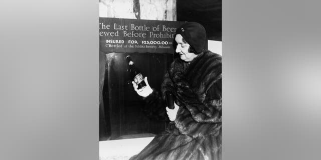 Rae Samuels holds the last bottle of beer that was distilled before prohibition went into effect in Chicago, Ill., Dec. 29, 1930. The bottle of Schlitz has been insured for $25,000. (AP Photo)