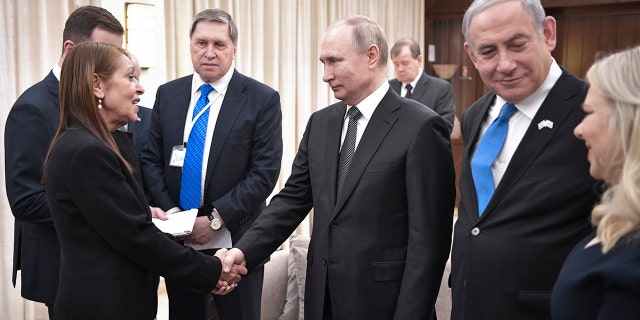 Russian President Vladimir Putin, center, shakes hands with Yaffa Issachar, mother of Israeli citizen Naama Issachar, who is jailed in Russia for drug trafficking, during the meeting with Israeli Prime Minister Benjamin Netanyahu, 2nd right, in Tel-Aviv, Israel, Thursday, Jan. 23, 2020.