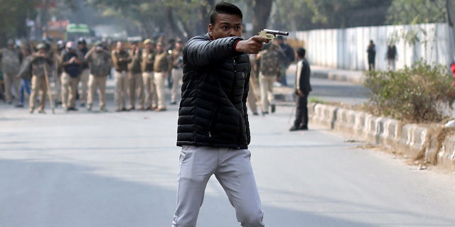 A man brandishes a gun during a protest against a new citizenship law outside the Jamia Millia Islamia university in New Delhi, India, on Thursday.